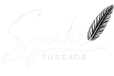 Elegant white brand logo for 'Syahi Threads' on a black background. The word 'Syahi' is written in a flowing, handwritten script with a detailed feather quill forming the dot of the 'i'. The word 'THREADS' appears below in a clean, minimalist uppercase font, separated by a graceful curved underline.